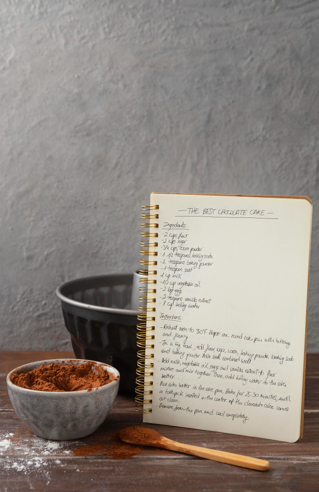 A recipes notebook, a bowl and a wood spoon